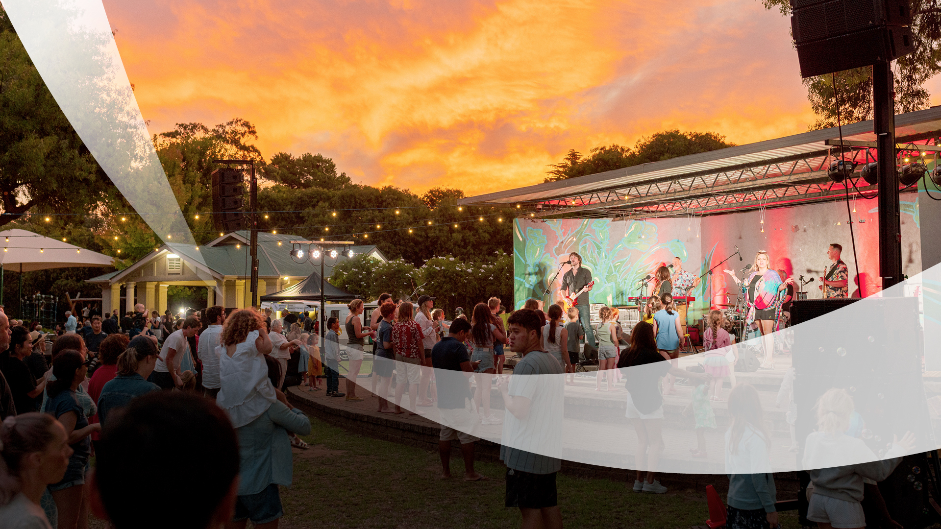 Group of people watching a band perform outdoors.